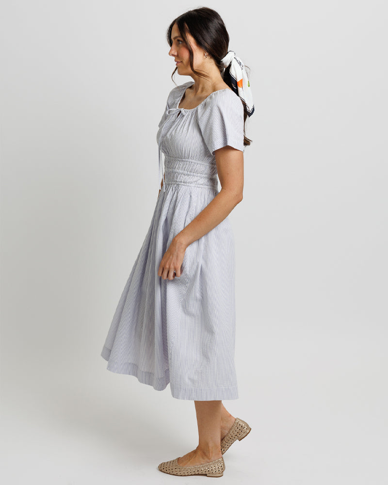 Woman wearing a light gray dress with short sleeves 