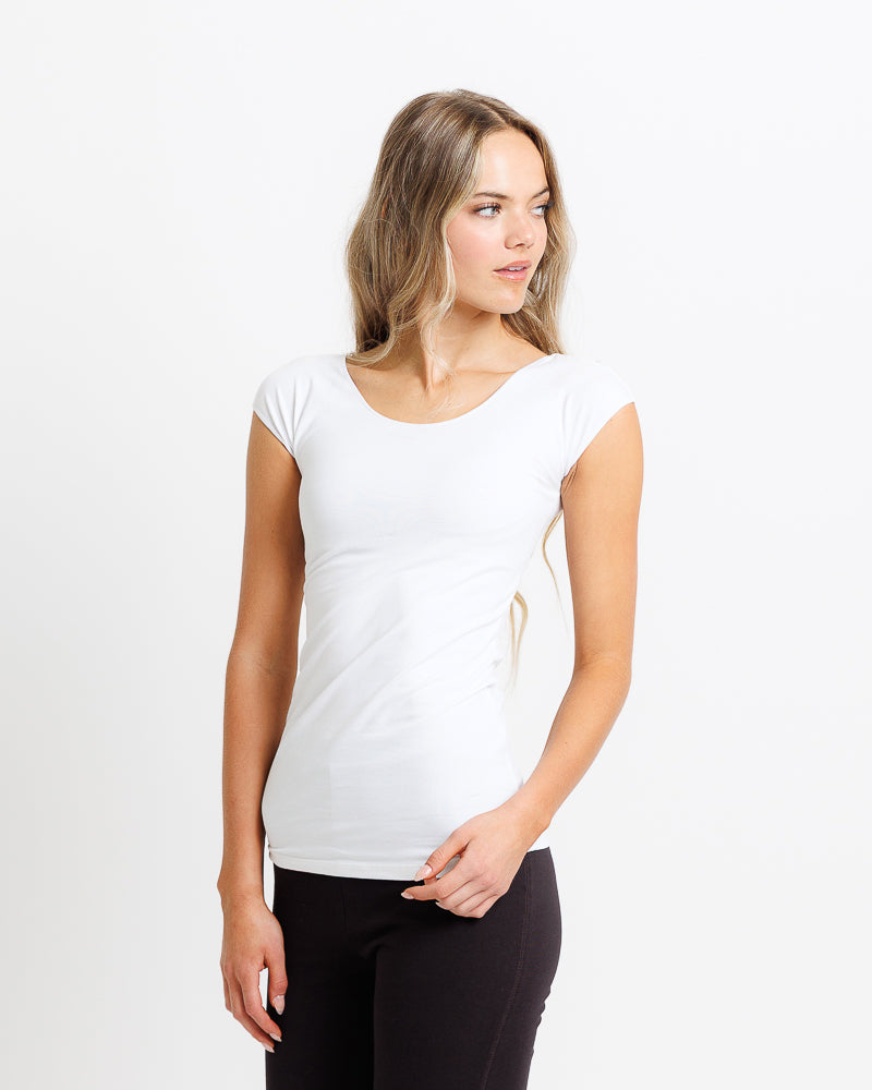 Woman in white fitted cap sleeve t-shirt for layering