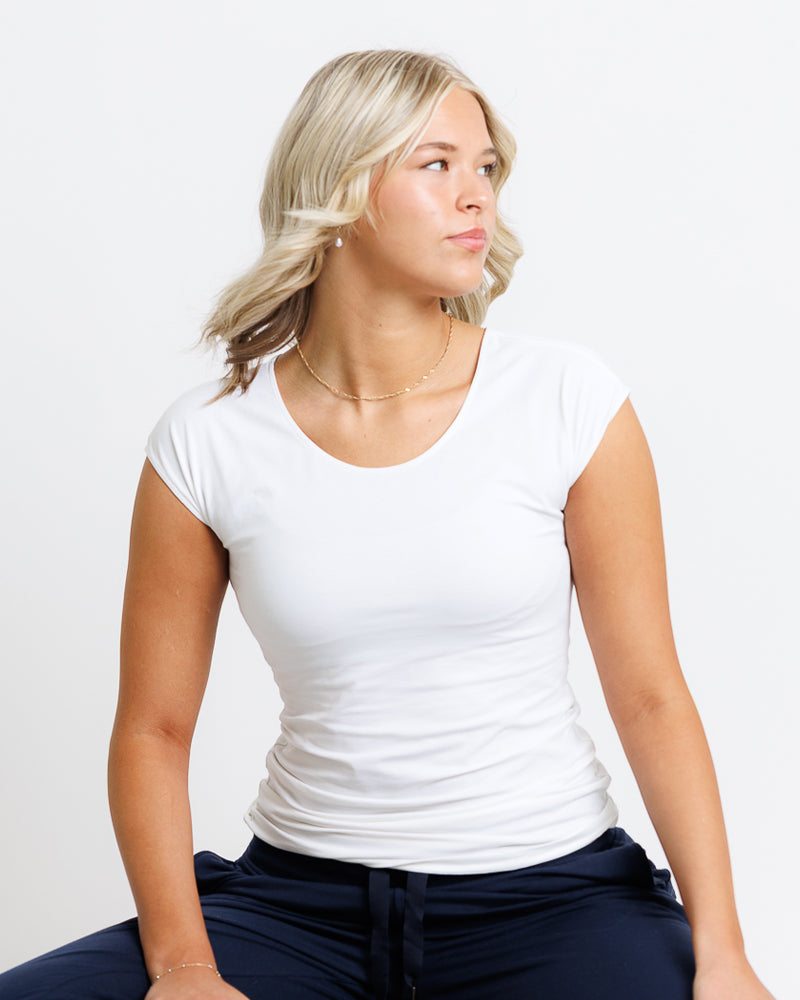 a blond lady wearing a white t-shirt and black  pants 