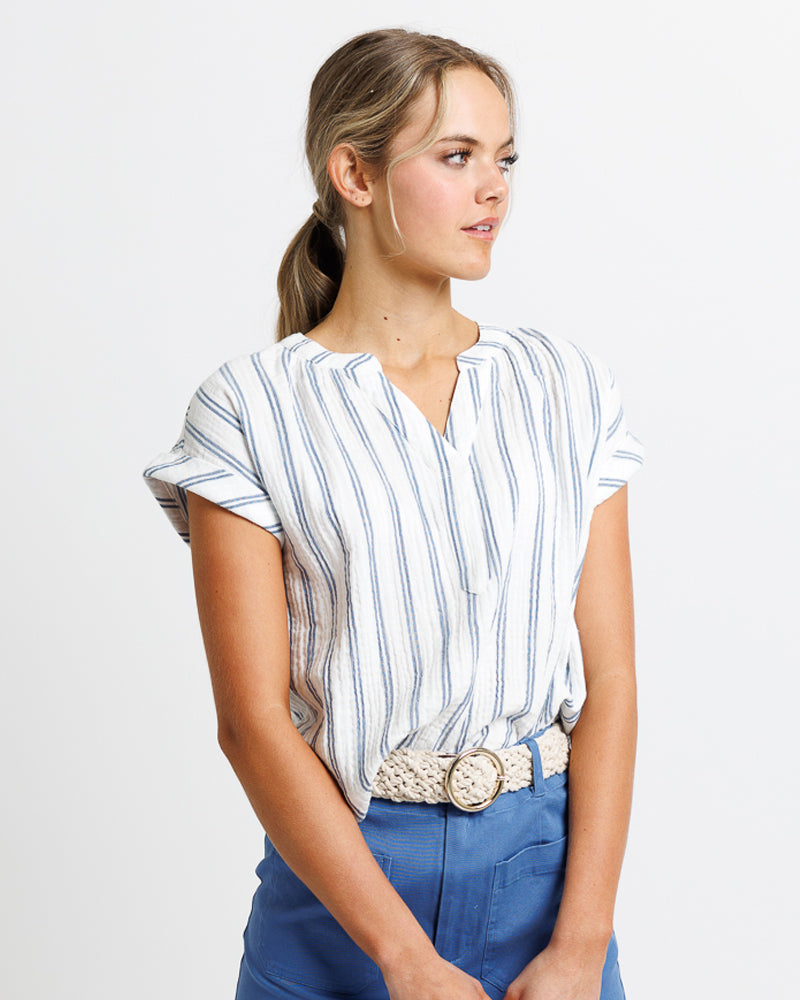 model with a striped linen shirt and blue pants 