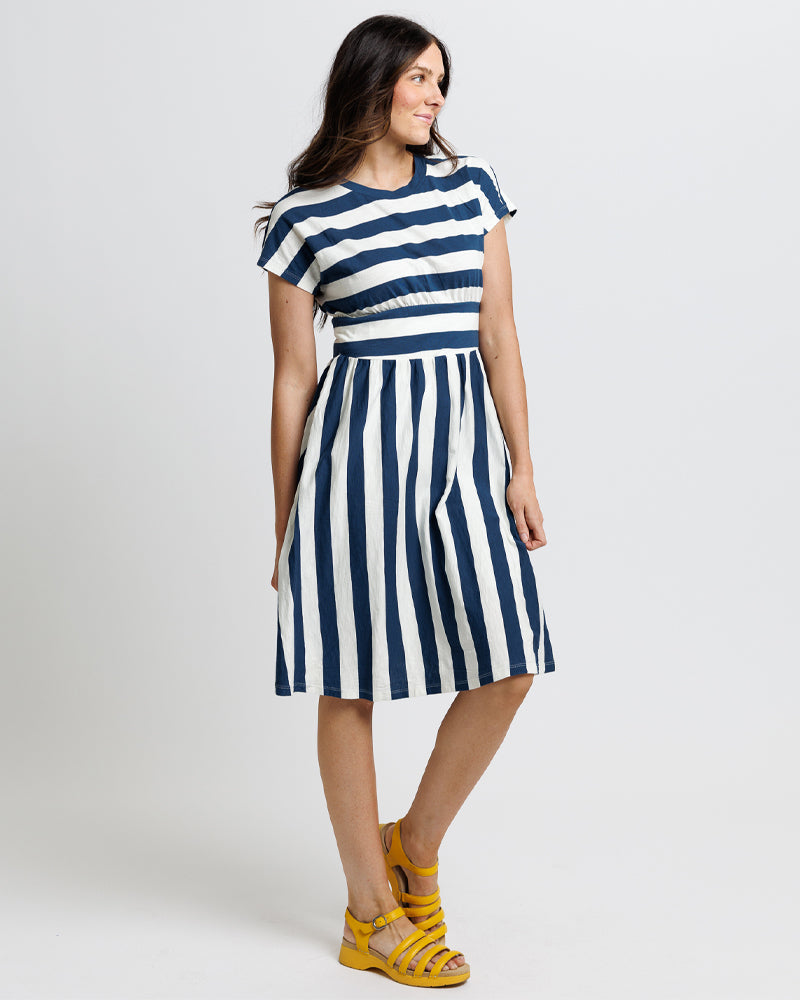 Brunette lady wearing a blue and white striped cotton dress 