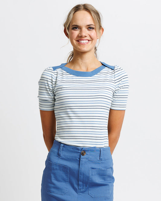 Woman wearing a striped shirt and blon a plain background