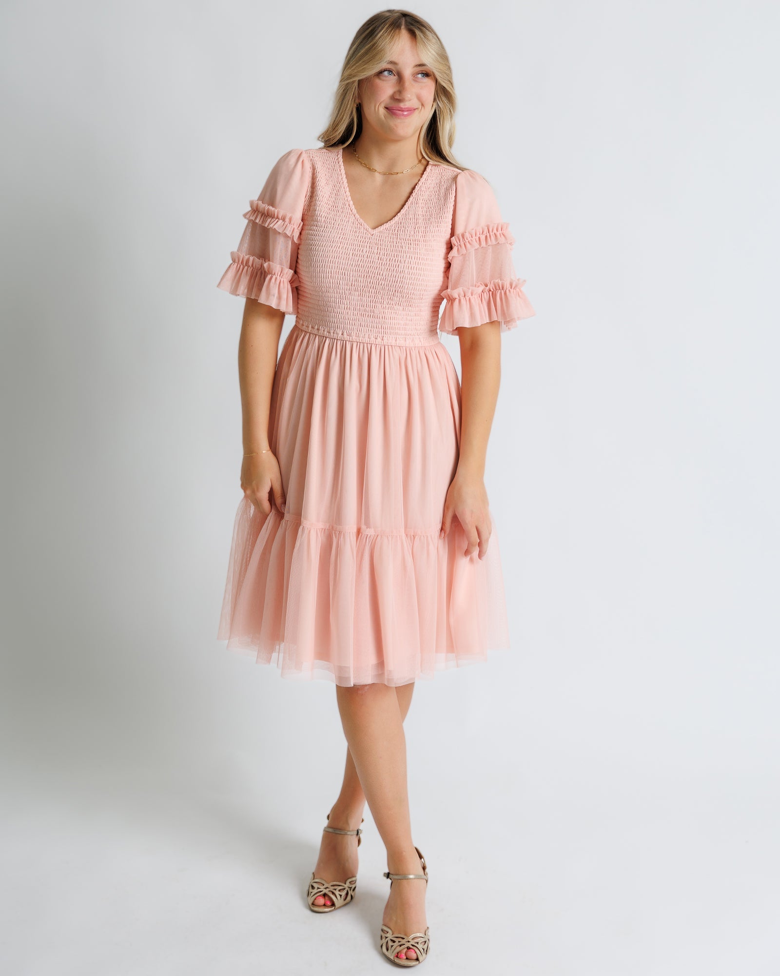 Woman wearing a pink dress with ruffle sleeves 
