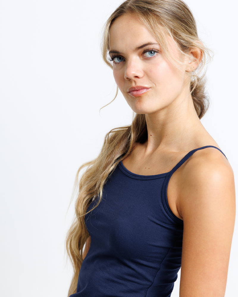 A young blond lady wearing a navy blue tank top 