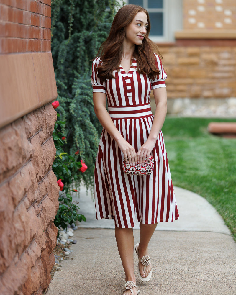 Woman in a red and white striped dress  and a beige sandals 