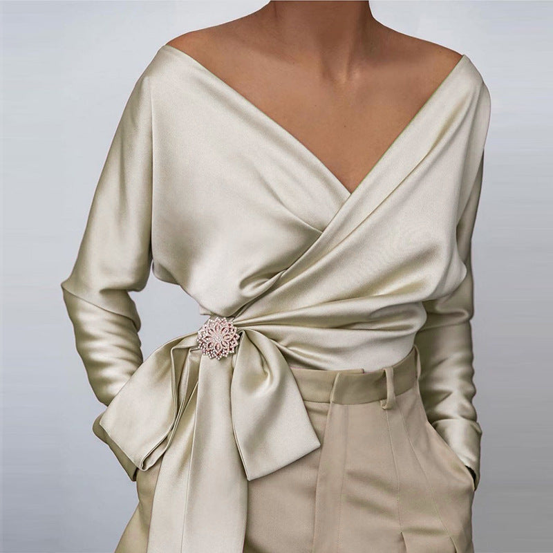 Women wearing beige off-shoulder wrap blouse with tie-front detail and long sleeves

