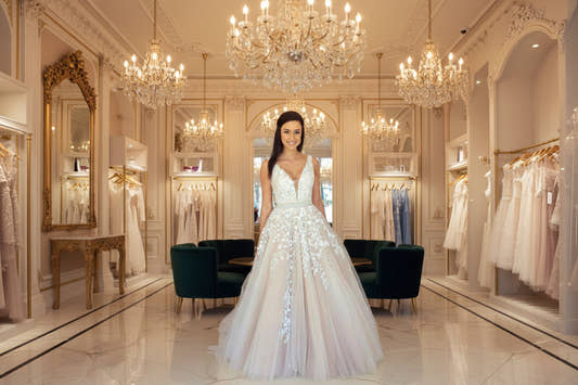 Off-shoulder lace wedding dress with flowing train in white
