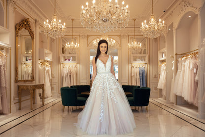 Off-shoulder lace wedding dress with flowing train in white
