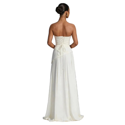 Back view of white strapless gown showing lace-up corset closure and flowing asymmetric skirt