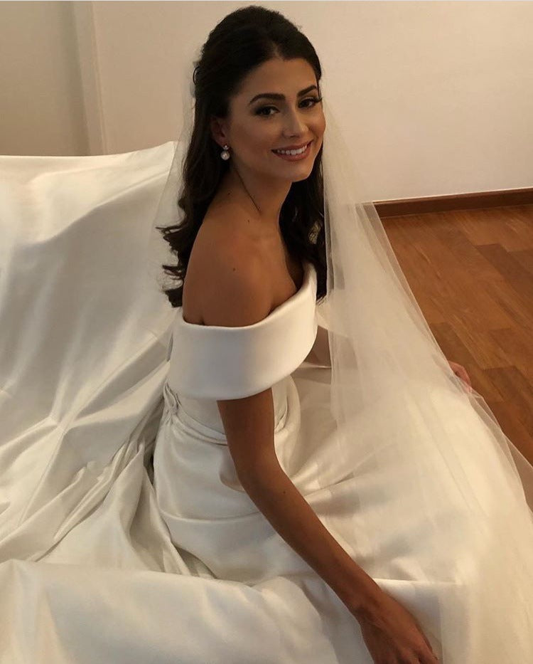 Ivory white off-shoulder wedding dress with A-line silhouette, side profile view
