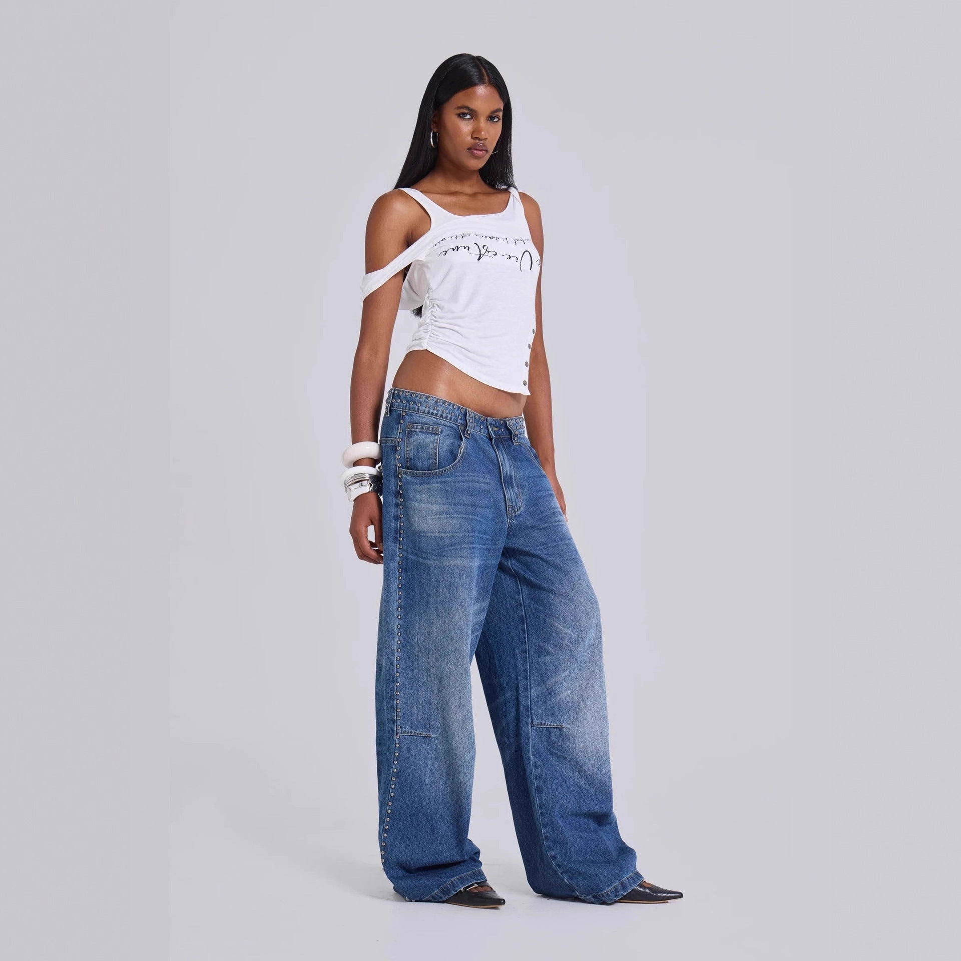 Women wearing super baggy jeans with multi-beaded embellishments and loose wide leg fit

