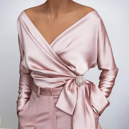
Soft light pink off-shoulder blouse featuring romantic wrap design and draped neckline