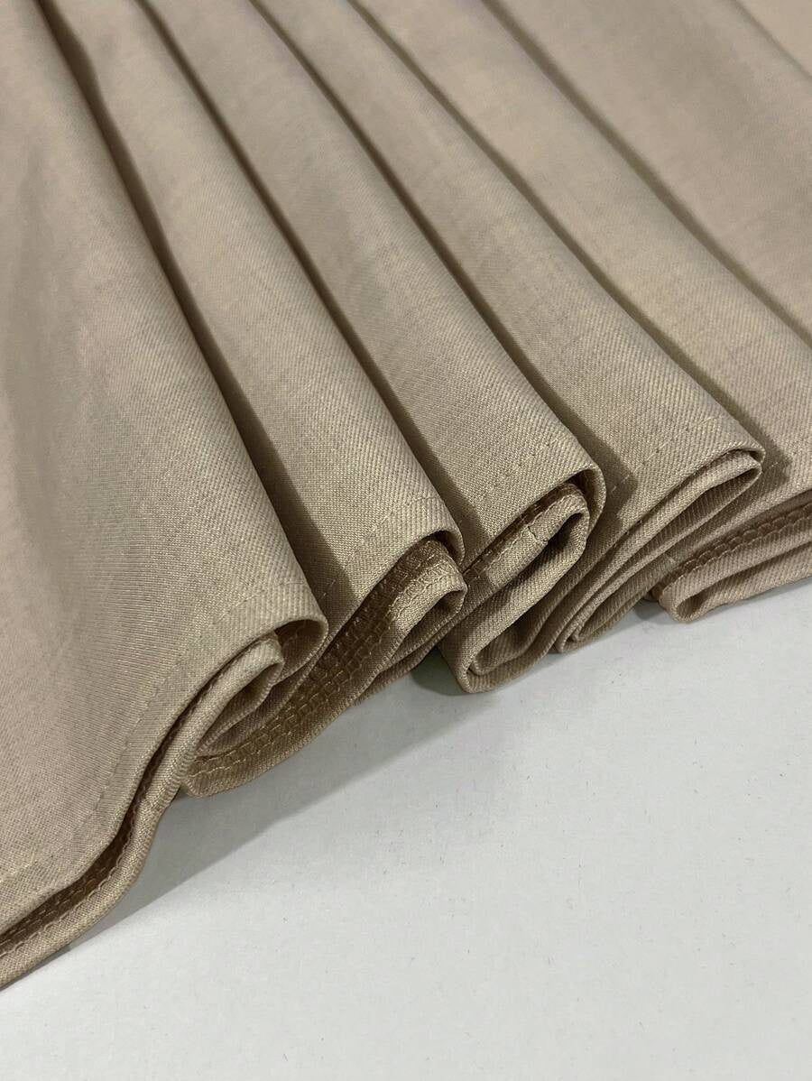 Folded beige fabric on a white surface