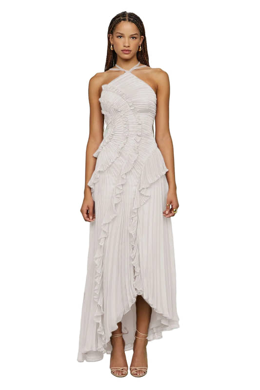 Woman wearing a white halter neck dress with ruffled layers 