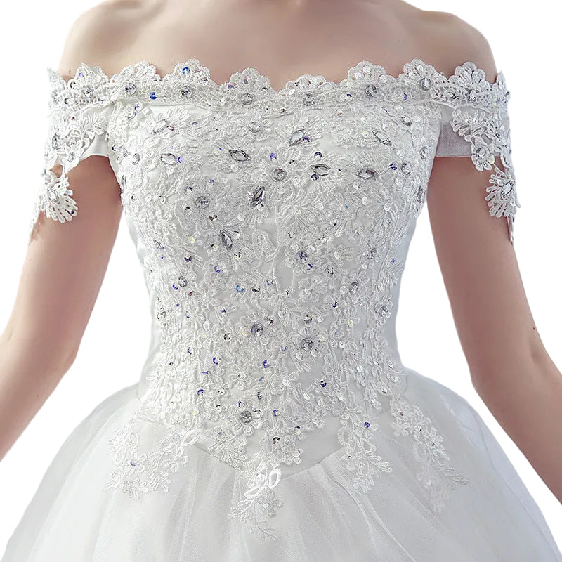 Romantic off-shoulder bridal dress with trailing skirt and French veil in white