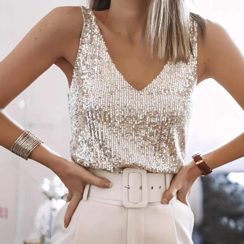 Person wearing a sparkly top and white pants 