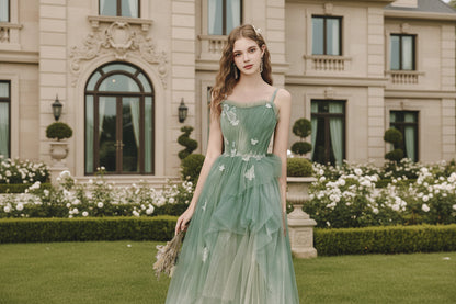 woman wearing  a sage green glitter tulle A-line gown with butterfly appliqués and floral lace waist

