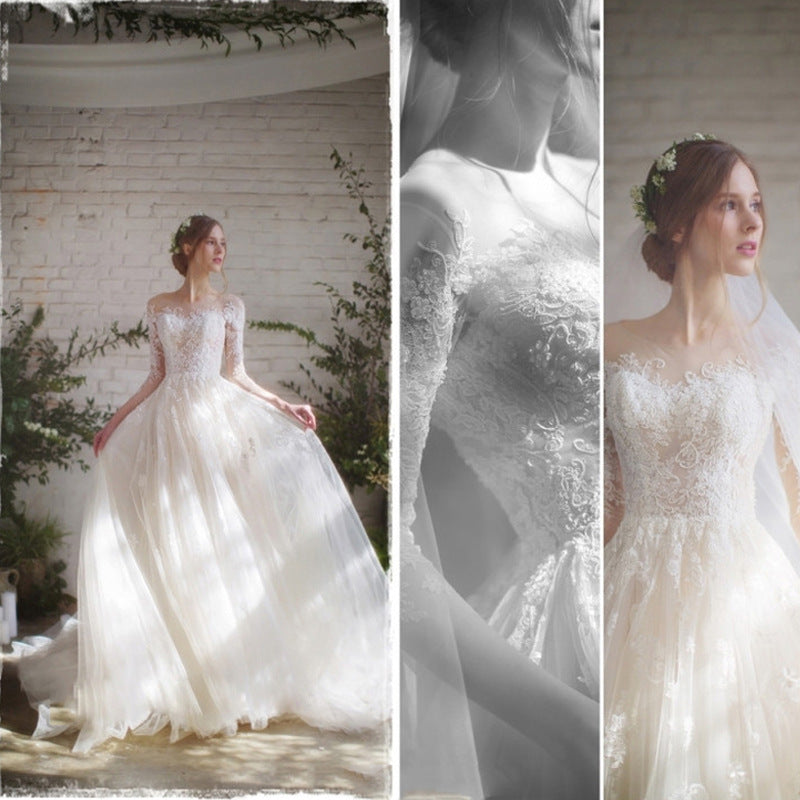 Floral lace embroidery detail on sheer three-quarter sleeves of ivory wedding dress

