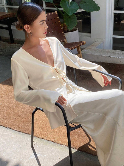 Woman in a white dress sitting outdoors on a chair.