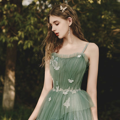 Close-up of butterfly appliqués and floral lace trim on sage green glitter tulle bodice

