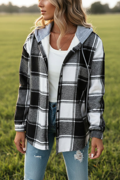 Short plaid hooded coat in black– front view showing above-hip length and wide-leg trouser outfit pairing
