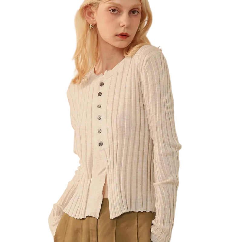 Woman wearing a cream ribbed cardigan with long sleeves and round collar 