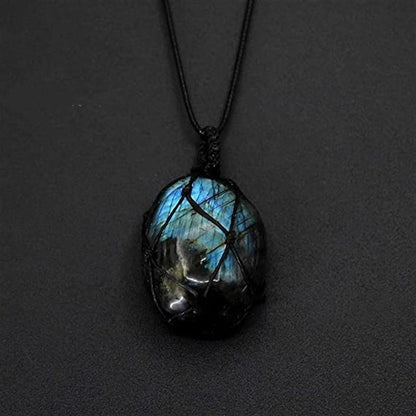 Labradorite stone pendant on a black cord against a dark background