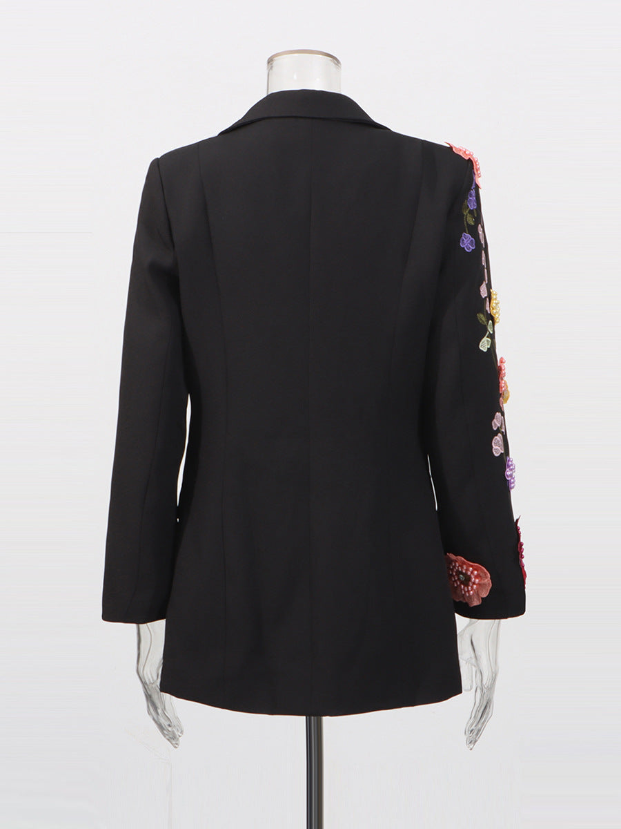 Black blazer with colorful floral embroidery on sleeves on a mannequin 