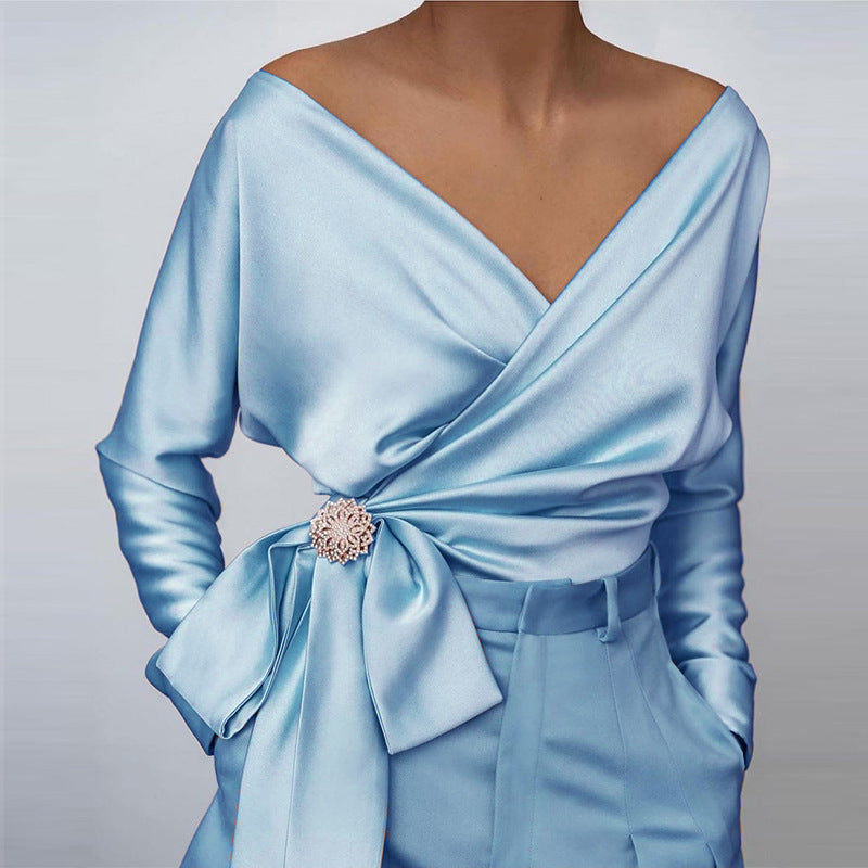 Light blue wrap top with off-shoulder neckline and adjustable tie-front styling
