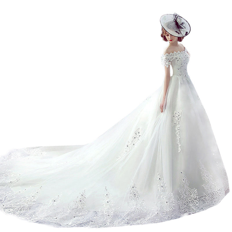 White trailing wedding dress with asymmetric off-shoulder neckline and French veil

