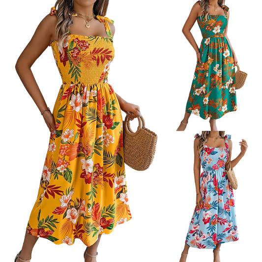 Yellow tropical floral smocked midi dress with tie straps and high waist — front view on model
