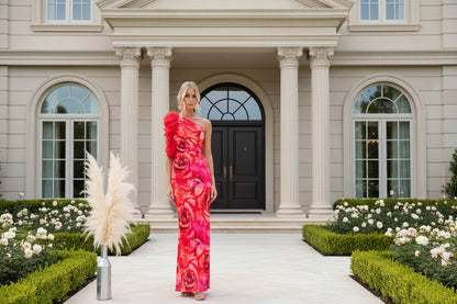 Woman wearing red sleeveless floral evening dress at formal event, full length view