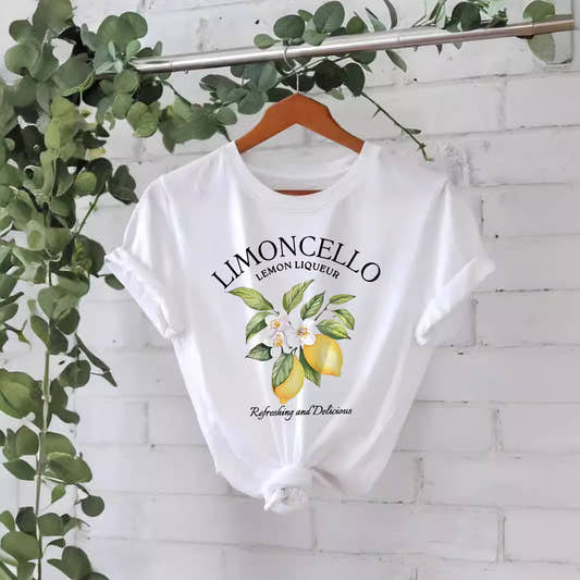 White Limoncello lemon print graphic t-shirt on hanger — "Refreshing and Delicious" botanical lemon design

