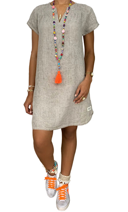 Person wearing a beige dress  made in 100 percent linen 