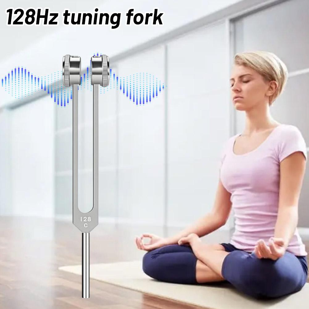 Woman meditating with a 128Hz tuning fork in a modern interior setting