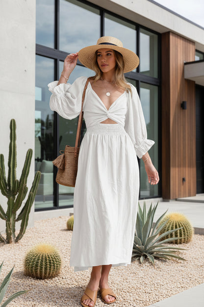 Woman wearing a white dress with cut-out design, holding a straw bag 