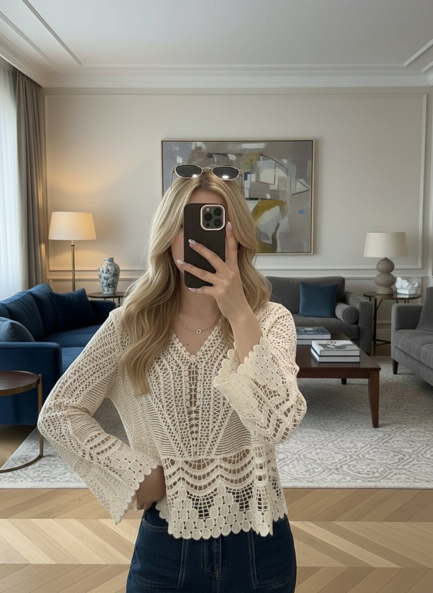 Person wearing a white lace top in a living room setting