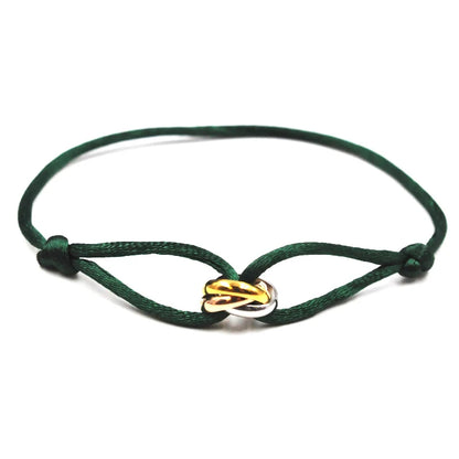 Green bracelet with a gold and silver on a white background