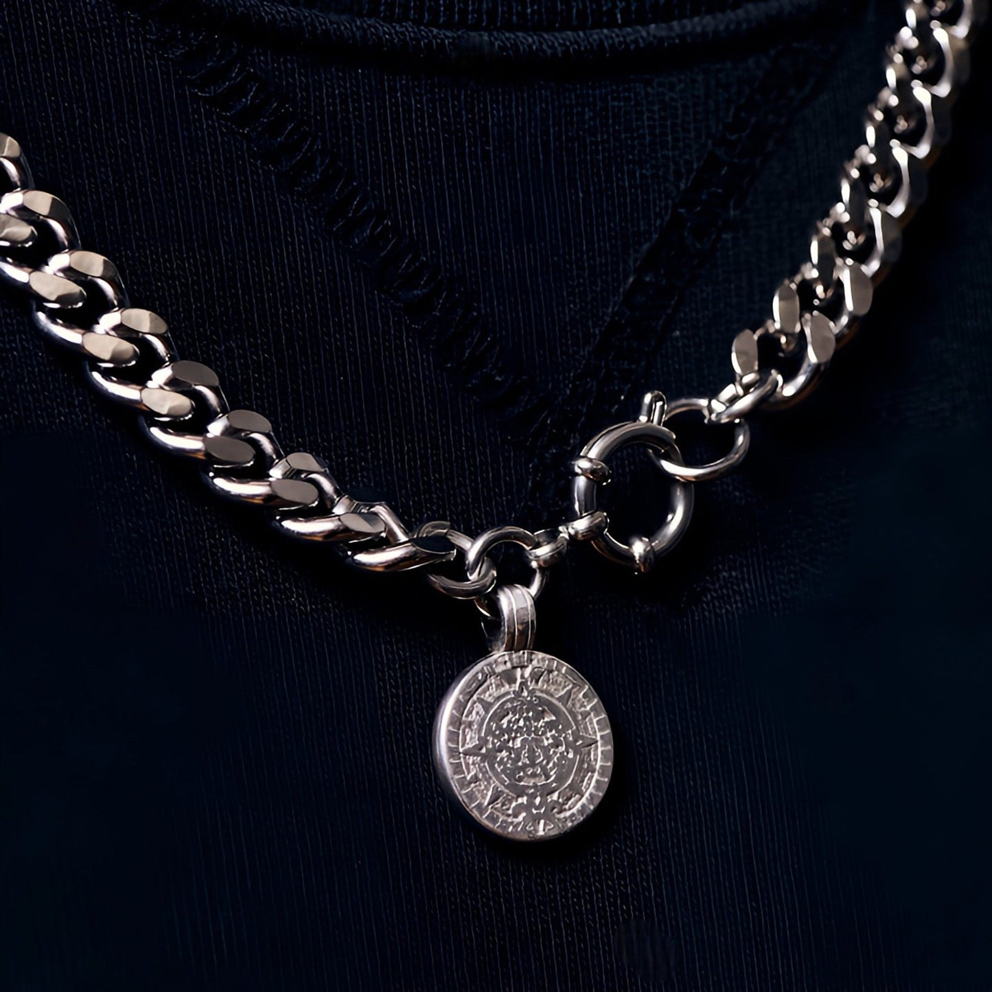 Silver chain necklace with a pendant on a black background