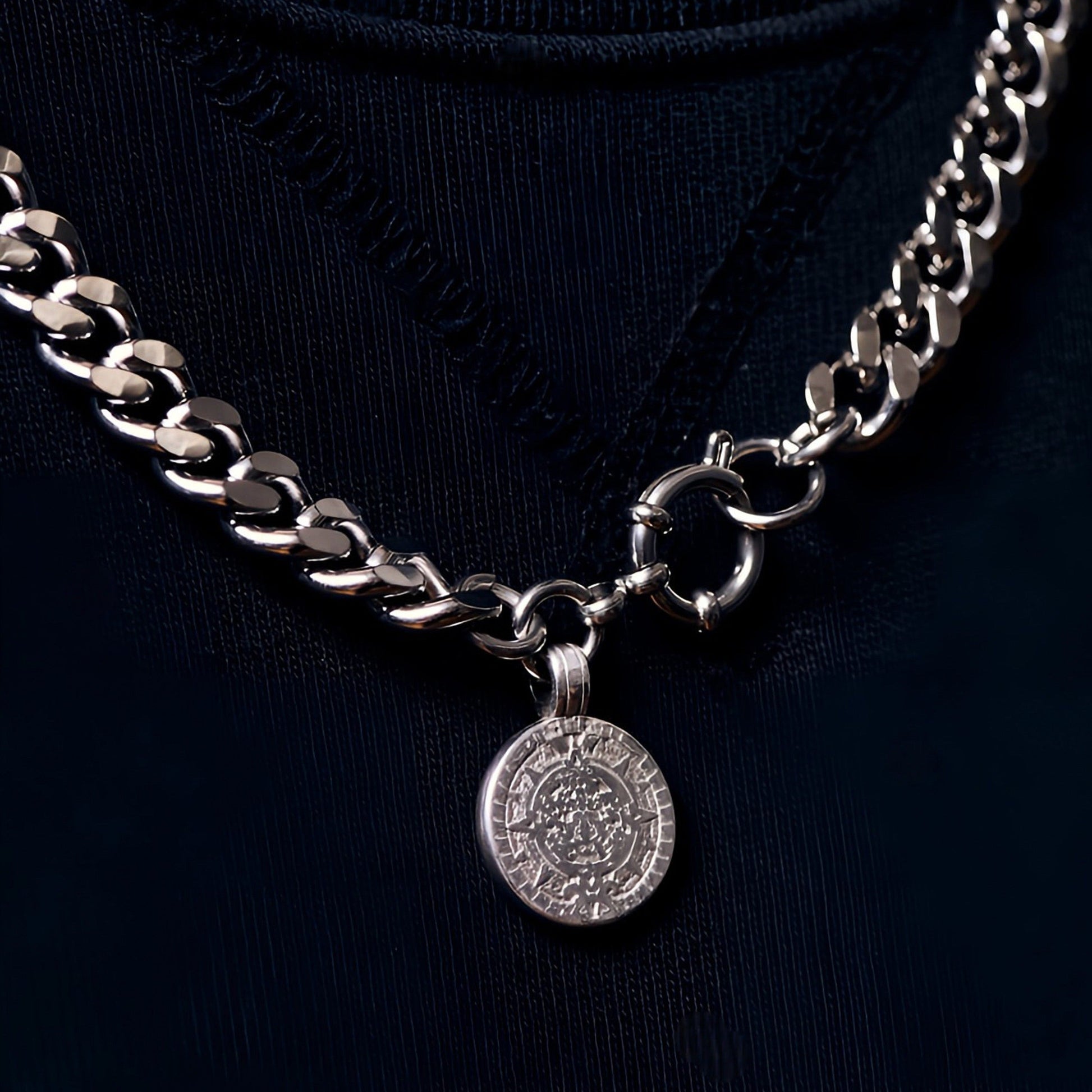 Silver chain necklace with a pendant on a black background