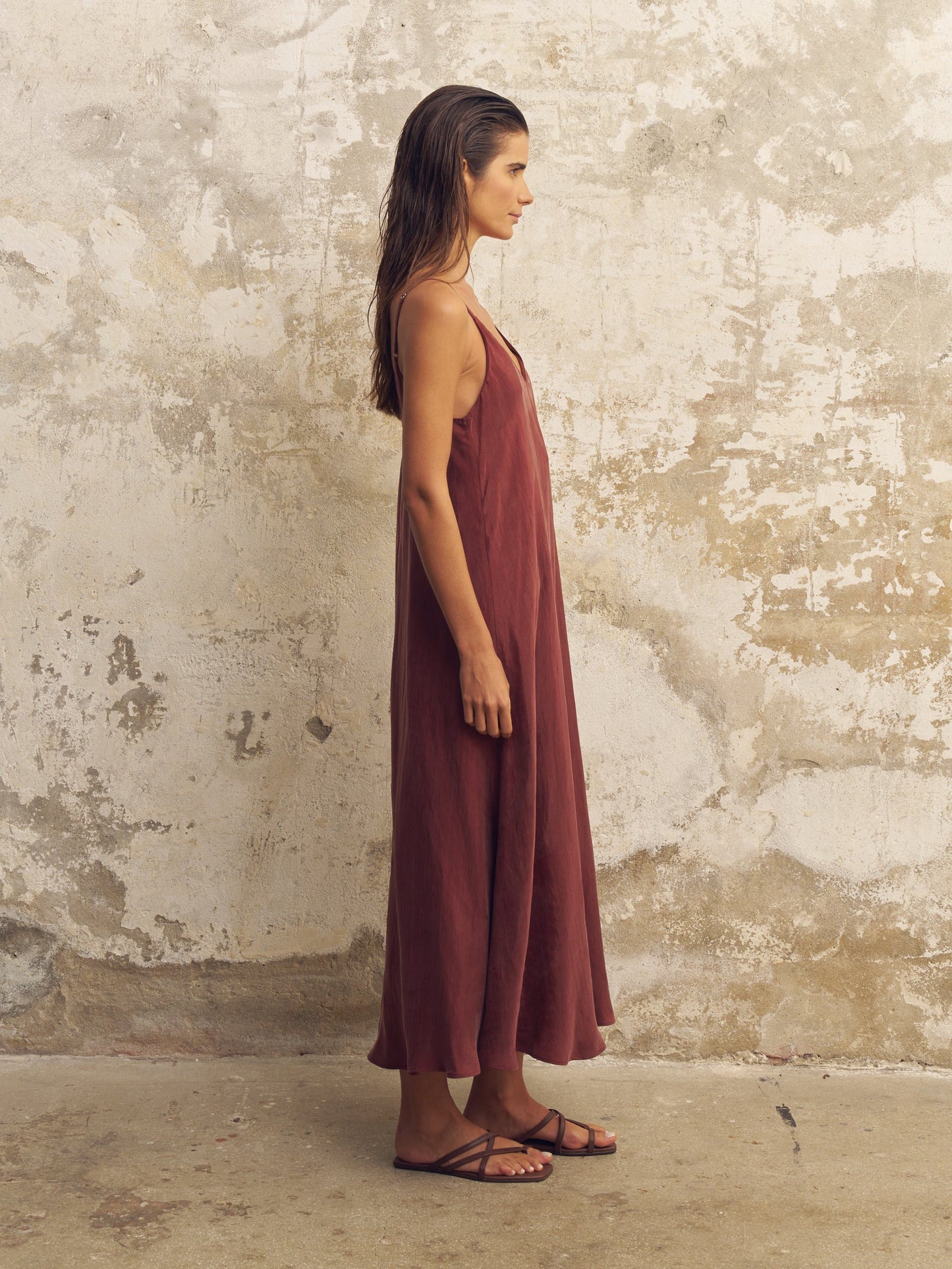 side of a woman in a long burgundy dress 