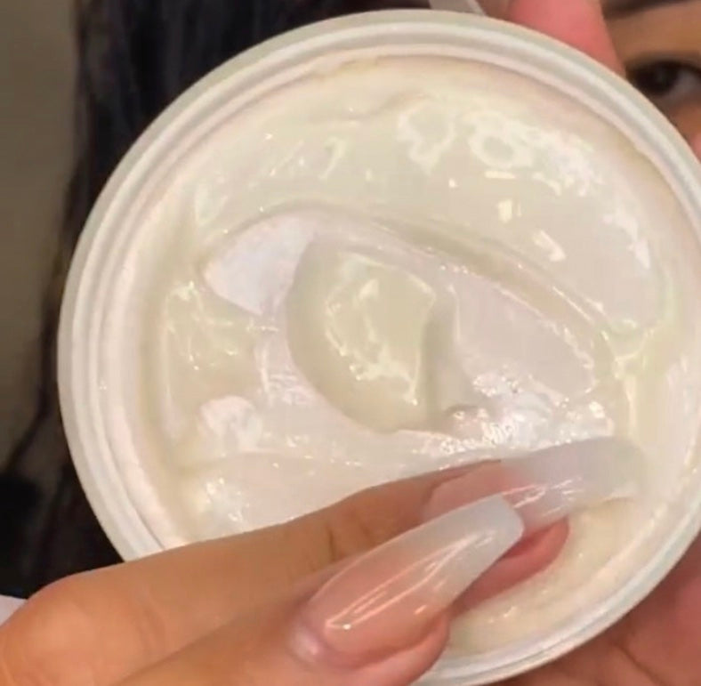 Hand holding a container of white hair ream 