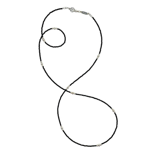 Black beaded necklace with silver clasp on a white background