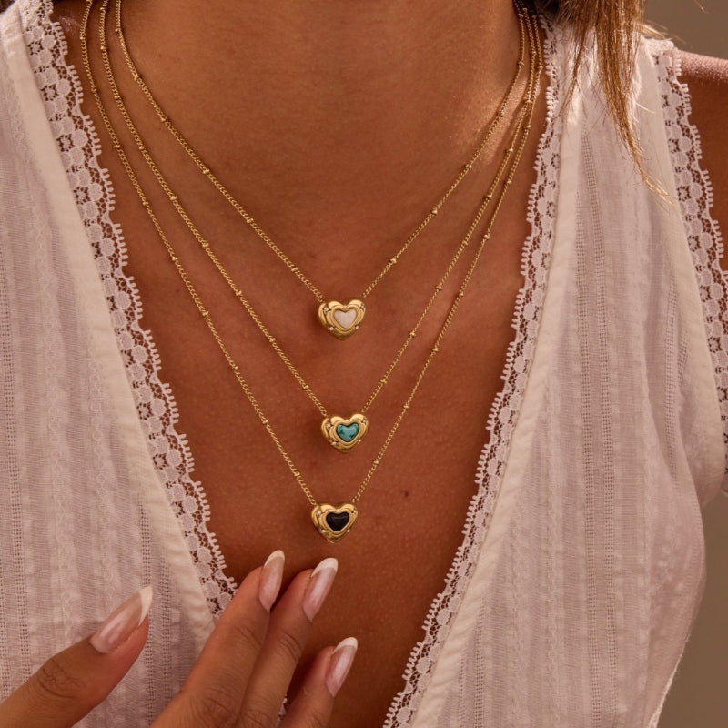 Three gold necklaces with heart-shaped charms 