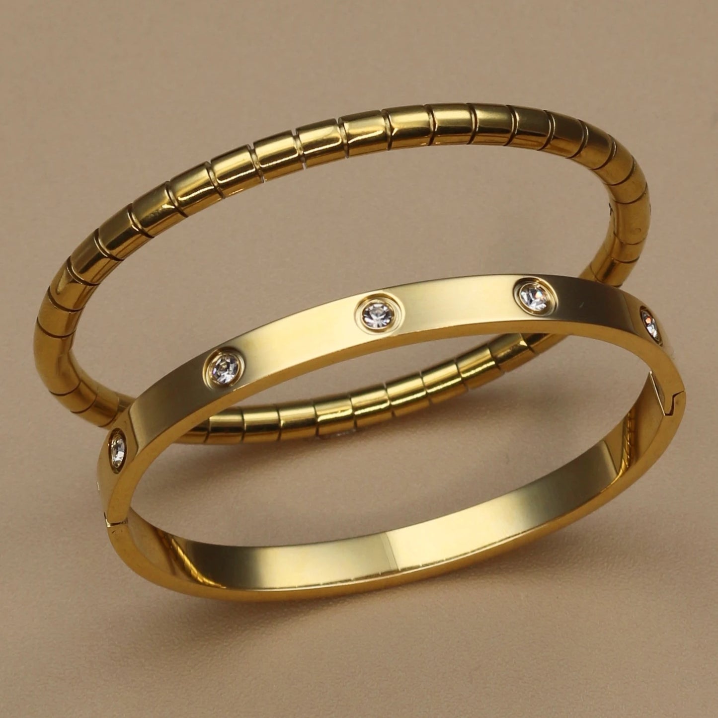 Gold stainless steel bangle set with zircon stones – ribbed and smooth bangles stacked together
