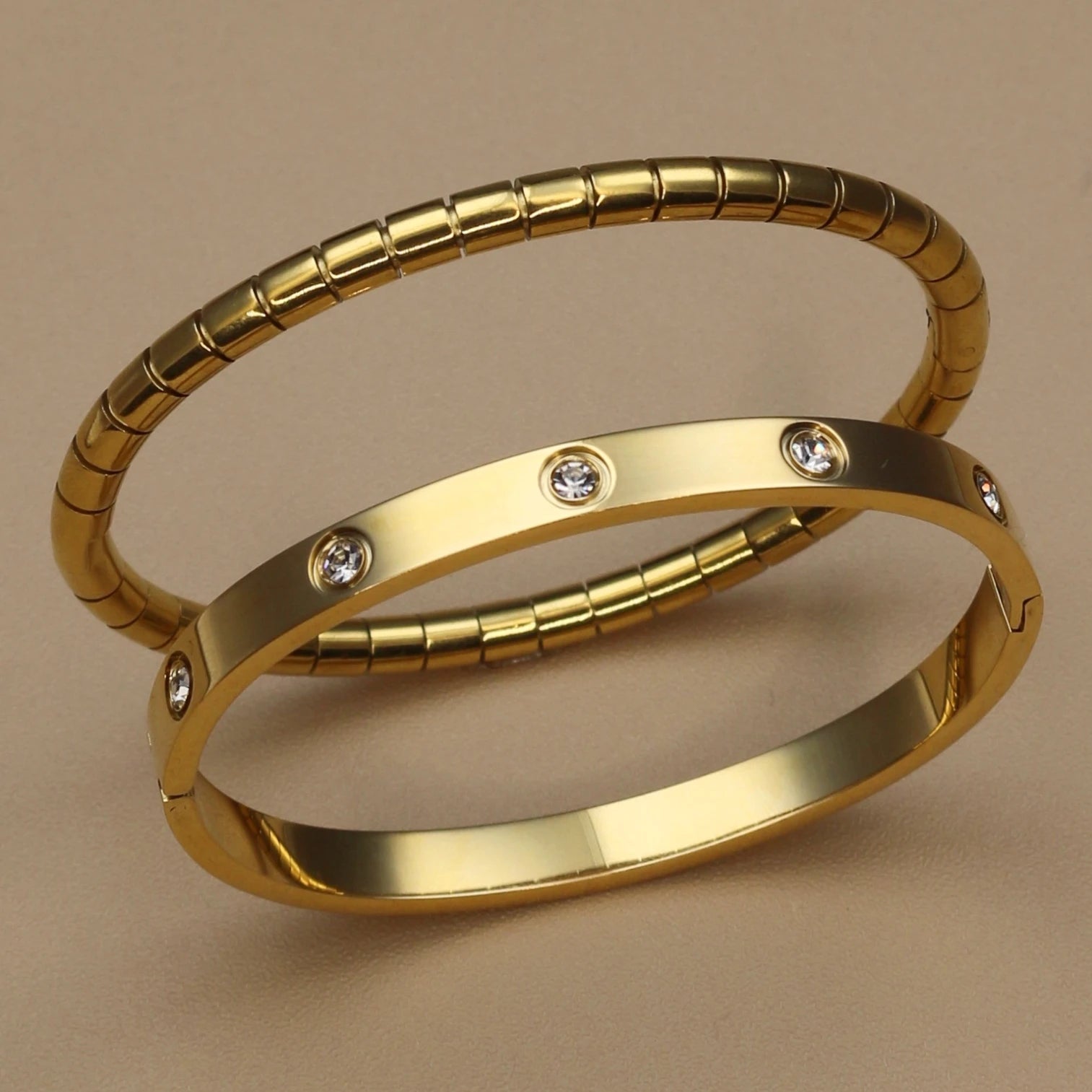 Gold stainless steel bangle set with zircon stones – ribbed and smooth bangles stacked together
