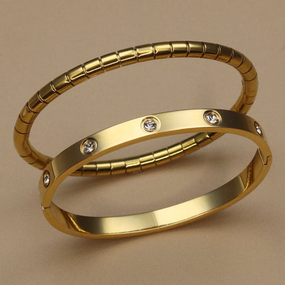 Gold stainless steel bangle set with zircon stones – ribbed and smooth bangles stacked together
