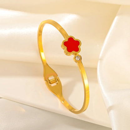 Gold bracelet with a red flower charm 