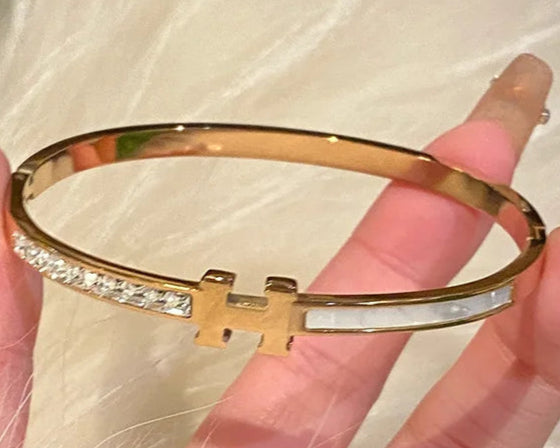 Gold bracelet with a lH ogo 