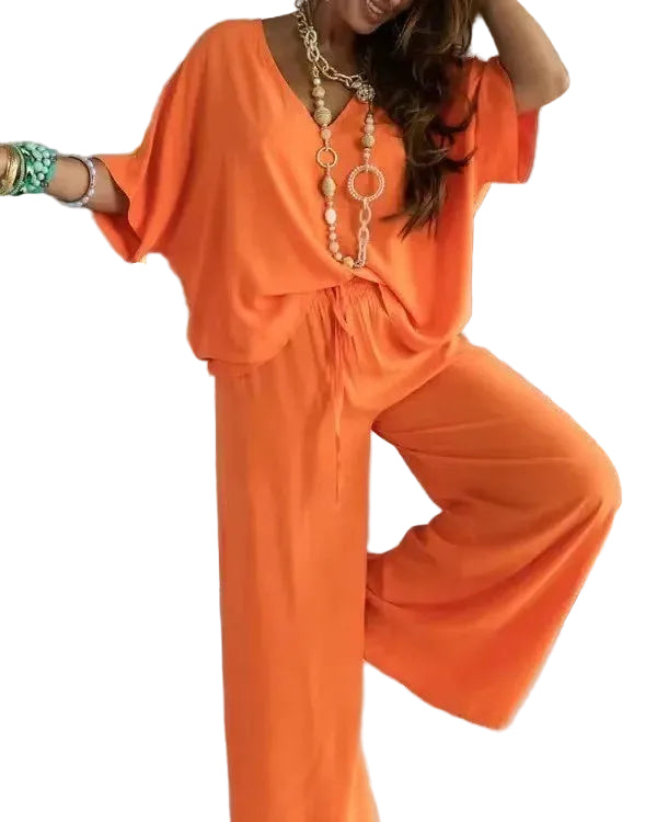 Loose fit V-neck blouse paired with high-waist wide leg pants`
